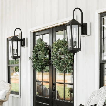 two outdoor wall lanterns on either side of a french door